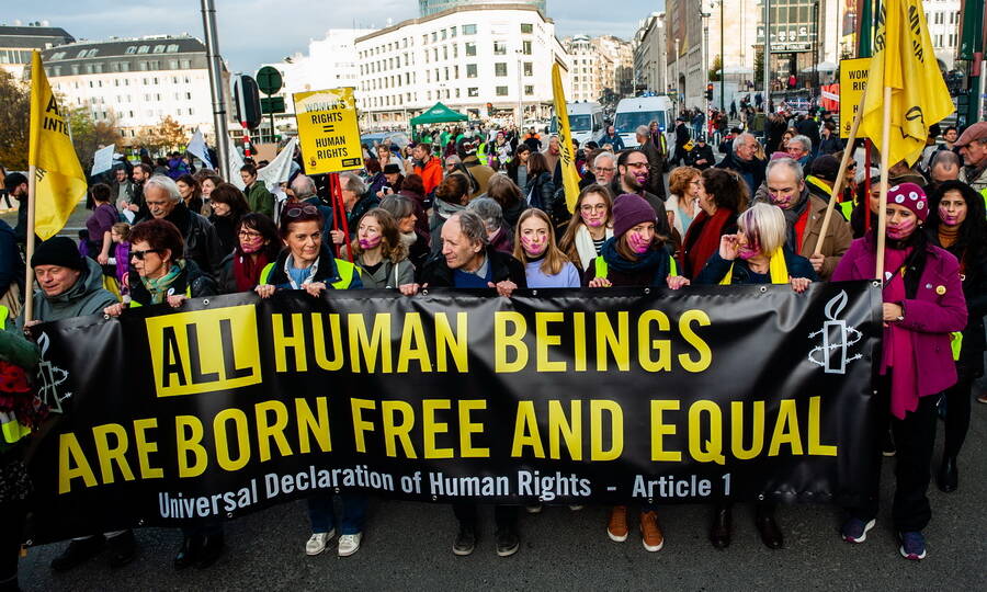 Демонстрация за равенство полов в Венгрии под эмблемами и цветами Amnesty International