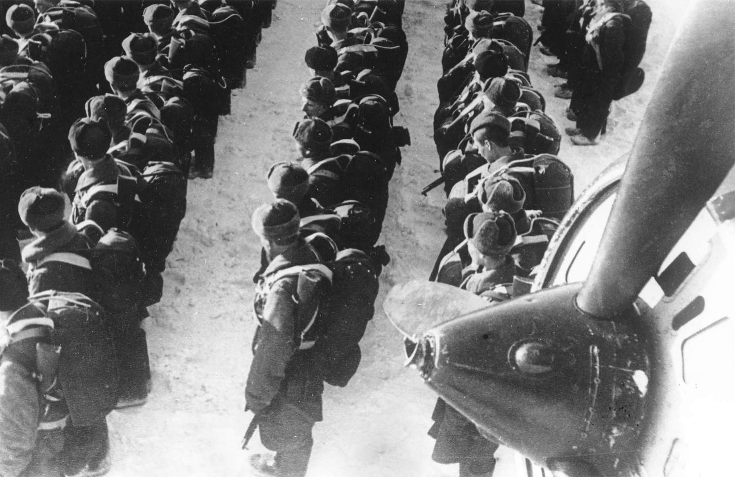 Построение десантников перед посадкой в транспортные самолеты ПС-84. Виден винт и мотор одного из транспортников